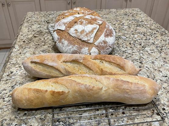 Photo of two baguette and two boule loaves of bread.