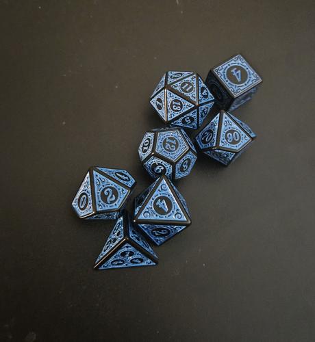 A full set of blue and black dice with very intricate, mystical engravings.