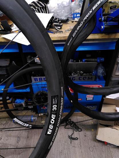 Roues Asterion e-one en carbone devant un établi avec des pneus GP5000