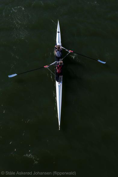 A rowing boat from above. Two people rowing.