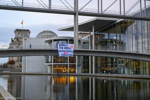 Aktivist*innen von Extinction Rebellion beim Banner Drop (Shell to hell / Ogoni people are not forgotten) für die Ogoni Nine, die mit 700.000 Ogoni gegen Shell protestiert hatten und am 10.11.1995 nach einem dubiosen Gerichtsprozess gehängt wurden. Berlin, 10.11.2023