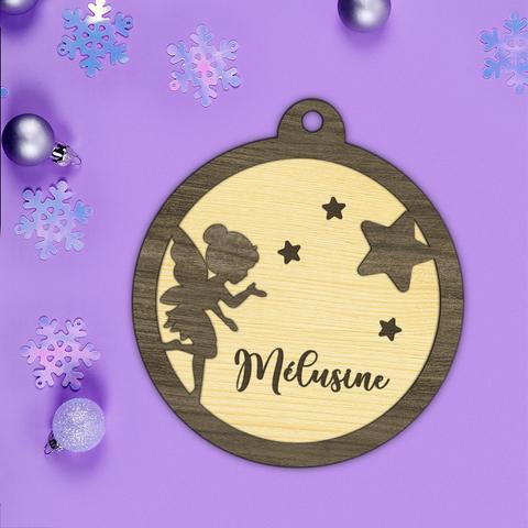 Boule de Noël en bois découpé et gravé représentant une petite fée entourée d'étoiles. La boule est personnalisée avec le prénom de votre choix. A retrouver dans notre boutique en ligne : ernestine-etcie.fr