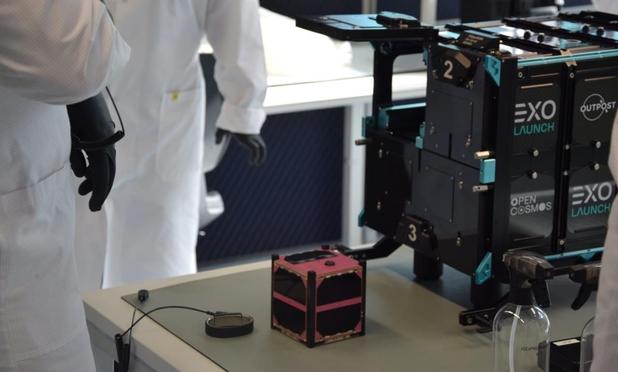 Pink 1U cubes at on table near spacex deployer.