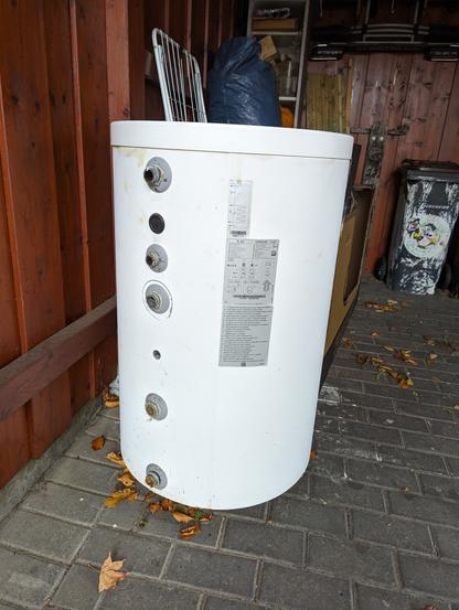Ein Warmwasserspeicher für eine Heizung. Man sieht die Anschlüsse und ein Typenschild.