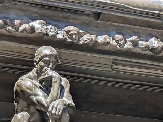 a "thinker" with a row of skulls behind