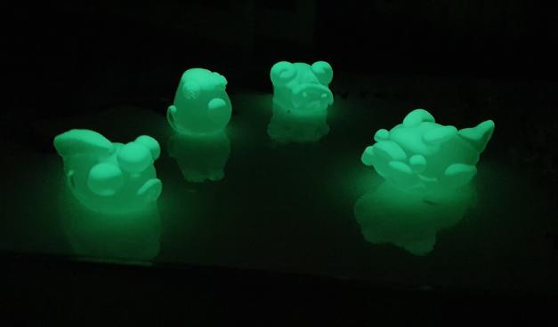 small resin green glow in the dark monsters against a black background