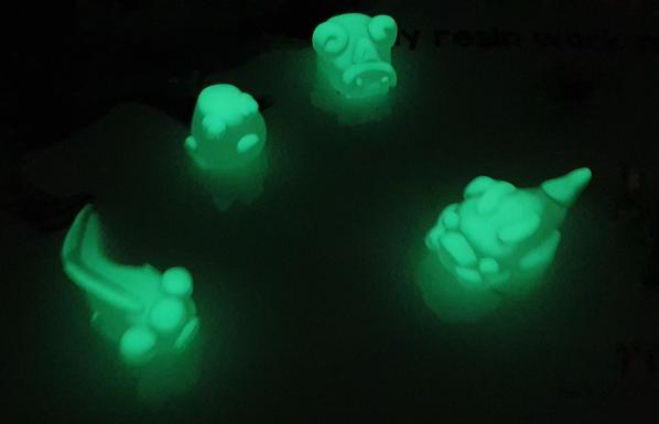 small resin green glow in the dark monsters against a black background