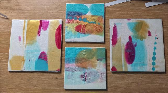 Four small abstract art pieces using teal, gold, pink and white.