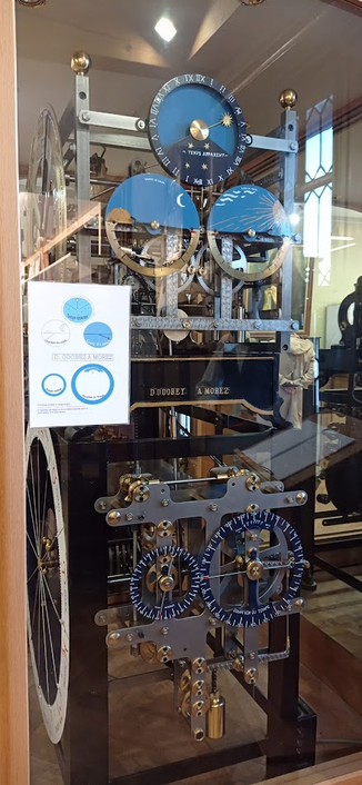 Horloge de Rémy Chauvin, vue latérale droite.
Cadrans, rouages, poids, dans un solide bâti métallique.