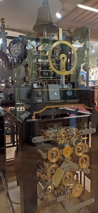 Horloge de Rémy Chauvin, vue latérale gauche.
Cloche, rouages dans un solide bâti métallique.