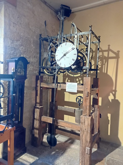 Horloge nue encagée et sur un bâti en bois, de 1810.
En haut, le mouvement et le cadran, en bas, le balancier et les contre-poids.