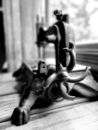 Old metal sewing machine on a windowsill. Black and white