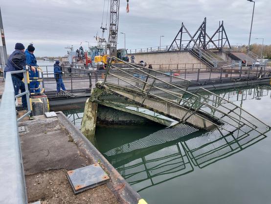 Schwimmgreifer und Mitarbeitende des WSA Oberrhein beim Einbau des Notverschlusses.