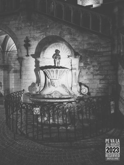 Zwart wit foto van het standbeeld van het Geraardsbergse Manneke Pis.
