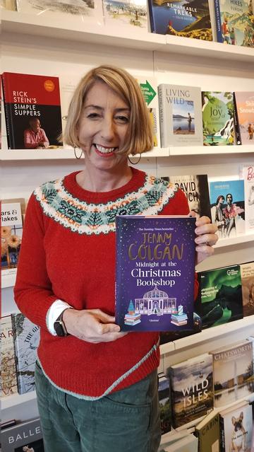 AUthor Jenny Colgan, in Christmas jumper, with her new novel, Midnight at the Christmas Bookshop, in the Edinburgh Bookshop