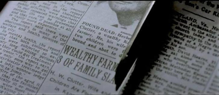 Scissors clipping out a newspaper item, with the headline “wealthy farm, 3 of family slain”