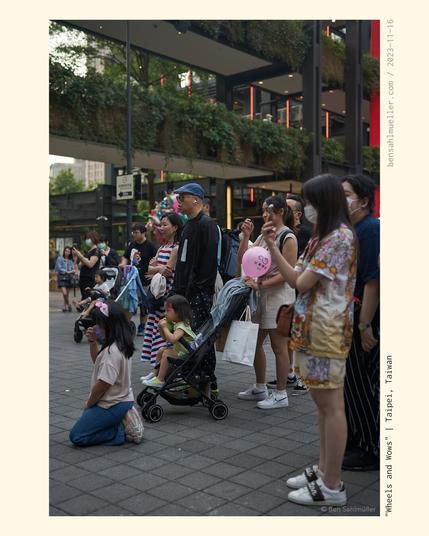 A family watching an athletic street performer in awe.