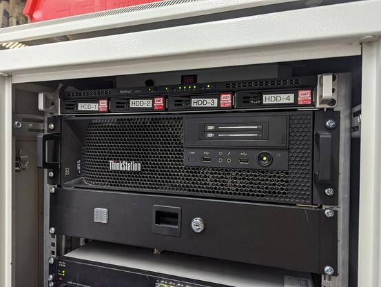 ein Servercomputer der Firma Lenovo. Vorne mit einer wabenförmigen schwarzen Plastik-Blende. ein paar Lampen binken.