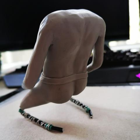 Man sieht den Rücken der Figur mitsamt fertig modellierter Muskulatur und ein paar Fusseln, die in der Clay hängen geblieben sind.