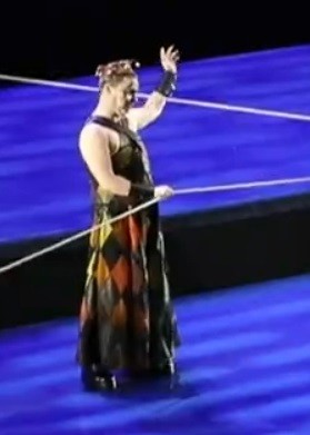 Dan's Monostatos at Oper Leipzig's current Zauberflöte production from this autumn. 

A man in an ankle length, mostly black, dress or very loose trousers, with rhombus or diamond patterns like a harlequin's on the lower part, in orange, red + yellow tones. A dark flame. The top is black and reveals his shoulders + arms. His left hand is lifted up and the right one holds onto a white rope. He's wearing leather wristbands.

Still running if you're in Germany, as I keep saying of these. Performances of the Magic Flute continue at least until Christmas.
