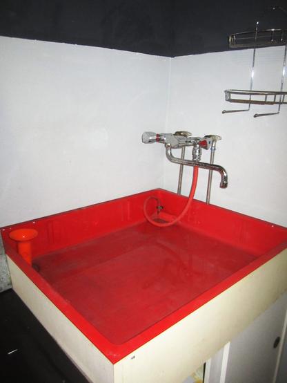 ein großes, rotes wasserbecken zum wässern von fotos.