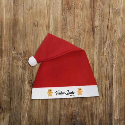 Bonnet de Noël rouge avec un pompon blanc et personnalisé avec le prénom de votre choix entouré de petits bonshommes de pain d'épices. A retrouver dans notre boutique en ligne : ernestine-etcie.fr
