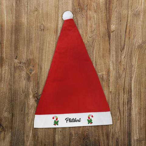 Bonnet de Noël rouge avec un pompon blanc et personnalisé avec le prénom de votre choix entouré de sucres d'orge colorés. A retrouver dans notre boutique en ligne : ernestine-etcie.fr