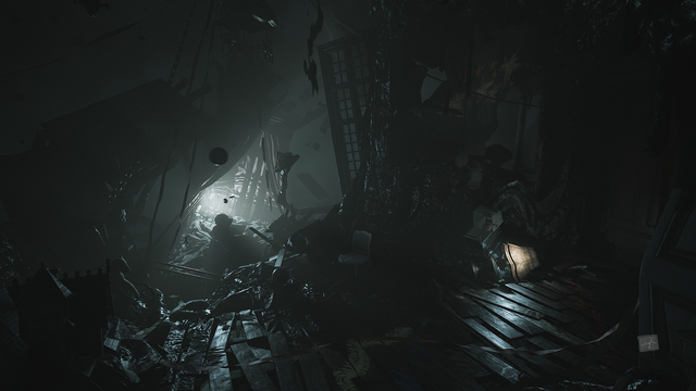 Zrzut ekranu z gry "Layers of Fear" przedstawiający zniszczony pokój dziecięcy, częściowo wiszący w otchłani. Drewniana podłoga, została rozerwana i poderwana w górę tworząc coś na kształt fal morskich. Spomiędzy przerw miedzy deskami wylewa się, spajając ze sobą różne części podłogi, sufitu i ścian, czarna, bezkształtna masa, która pulsuje niczym żywy, pasożytniczy organizm. Daleko w tle, na oderwanym od reszty i oddalającym się fragmencie pomieszczenia, znajduje się mosiężne łóżeczko dziecięce częściowo osłonięte baldachimem. Z łóżeczka dobywa się jasne, trupio-blade światło. Po prawej stronie, tuż obok drzwi, w ścianie stworzonej z zastygłej czarnej masy, znajdują się drzwi, a tuż obok nich wózek dziecięcy z przerażoną, porcelanową lalką i lampa z abażurem oświetlająca część tego co kiedyś było pomieszczeniem. Na podłodze walają się na wpół zniszczone zabawki pokryte czarnym szlamem, stopione ze sobą tworząc bliżej nieokreślone kształty.