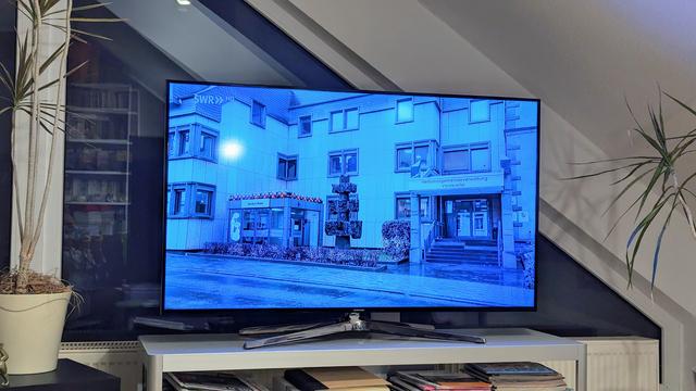Foto von einem Fernseher. Zu sehen ist das eine Reportage zum Amt-o-Mat: Gebäude der Verbandsgemeindeverwaltung Vordereifel mit den kleinen Glaskasten davor.