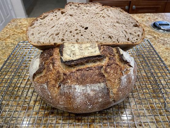 Photo of loaf of boule bread cut in half so can see the crumb structure.