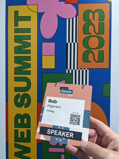 Photo of my speaker badge in front of a Web Summit poster