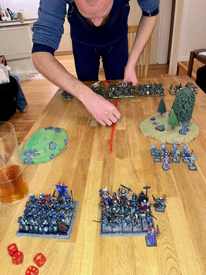 Mann spiller Warhammer Fantasy Battles. Ølglass. Miniatyrfigurer.