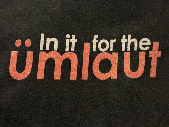 Photo of tshirt I designed years ago with the logo: In it for the ümlaut on black background.