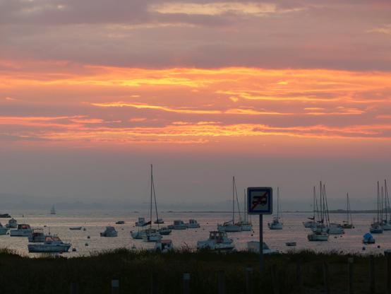 Nuage rouge au dessus des bateau au mouillage