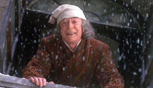 Michael Caine as Ebenezer Scrooge leaning out a window.