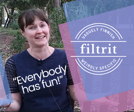 Smiling woman sitting on a bench outside, text "Everybody has fun!" and the logo for "Filtrit- vaguely Finnish, weirdly specific" placed over the image.