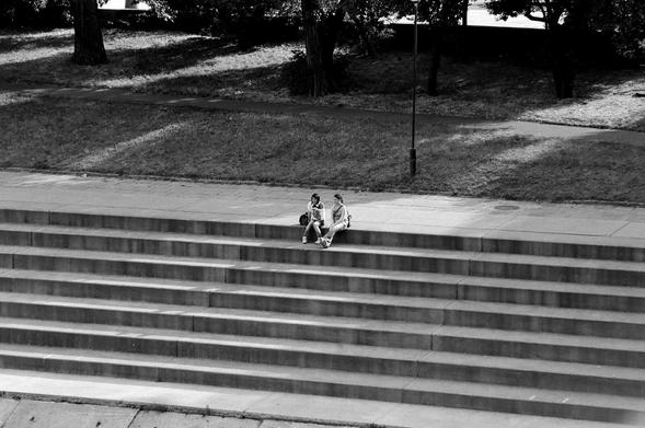 Two girls sitting on the stairs on the riverbank