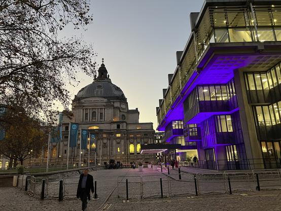 The old and the new. The Queen Elizabeth II Center in purple light to the right, and Central Methodist Hall on the left.