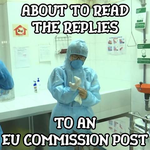 Photo of a person (presumably a doctor) in a hospital, wearing a protective suit, complete with a face mask, in process of putting on a pair of gloves. The picture has a large text added to it, which reads: ‘About to read the replies to an EU Commission post’. The font looks nice and just a little bit funky.