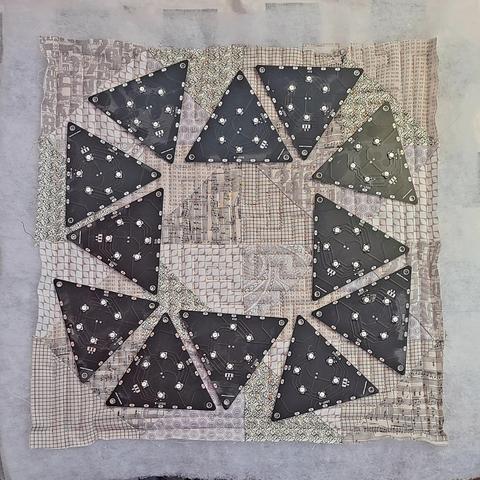 Time for Tessellation quilt top with light emitting diode display printed printed boards laid out like a clock face.