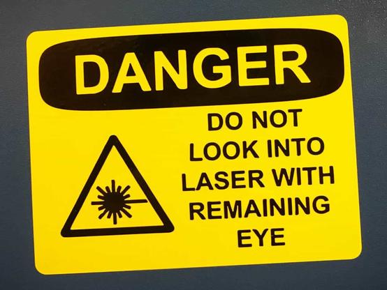 A warning label reading "Caution: Do not look into laser with remaining eye."