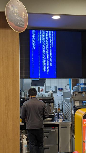 Drei Bildschirme über dem Bestelltresen von McDonald's. Normalerweise mit aktuellen Angeboten gefüllt, aber nicht heute: Zwei sind schwarz, der dritte zeigt 90° gedreht einen Bluescreen.