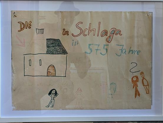 Eine Kinderzeichnung mit der Schrift "Die KIrche in Schlaga ist 575 Jahre.
Dabei ist das Wort Kirche mit einem Symbol der kleinen Kirche mit zwei "Minifenstern" und einer Tür dargestellt, darunter und daneben sind Kinder (oder Menschen?) dargestellt.