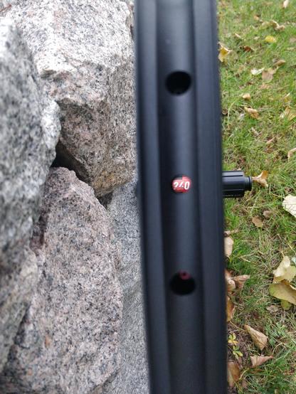 Blick durch das Ventilloch einer schwarzen Fahrradfelge. Im Loch ist der Schriftzug "240 DT swiss", welcher sich auf der Nabe befindet, zu sehen.