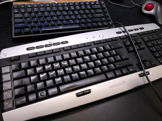abgenutztes CyMotion Master-Keyboard neben billiger/kompakter China-Plastik-Tastatur