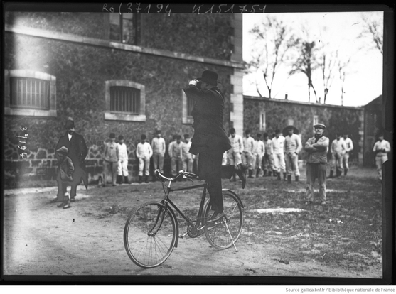 photo historique d'un cycliste debout sur son vélo (à l'arrêt) muni de jumelles
