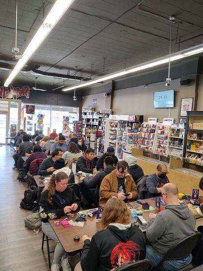 Many players sit together playing Lorcana at Hairy Tarantula