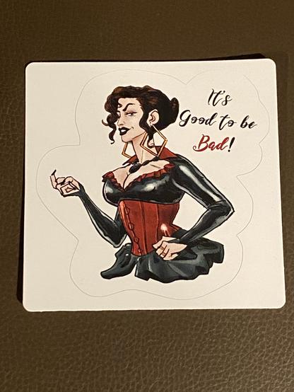 Sticker of Lady Chamberlain, smiling. On the right, a text says “it good to be bad!”