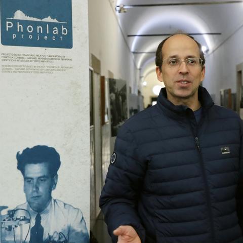 Quintino Lopes junto ao painel de entrada da exposição, onde se vê uma foto do Armando de Lacerda e se lê Phonlab Project