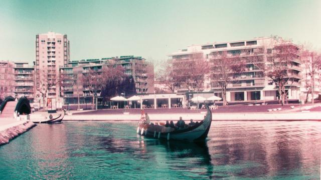 A traditional fishing boat filled with tourists floats along the canals of Aveiro, Portugal.